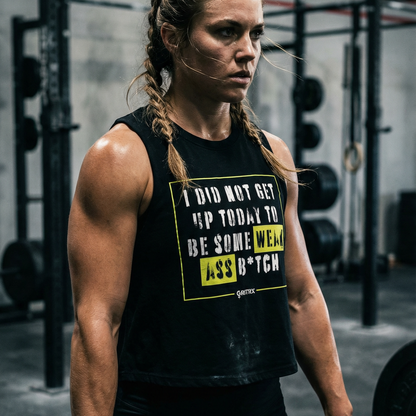 Woman lifting weights in a gym wearing a black tank top with text.